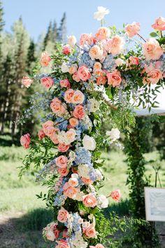 an outdoor ceremony with flowers and greenery