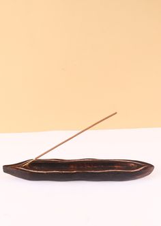 a long piece of food sitting on top of a white table next to a brown wall