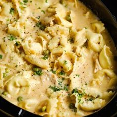 a pot filled with pasta and broccoli covered in cheese sauce on top of a stove