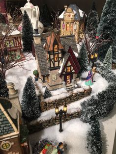 a christmas village with houses and trees covered in snow