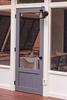 the front door to a restaurant with a table and chairs