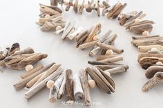 driftwood pieces arranged in the shape of a wreath on a white surface with text overlay