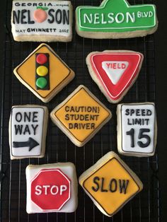 cookies decorated with street signs and traffic lights on a cooling rack, including one for nelson blvd