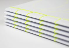 stack of white notebooks with yellow lines on them