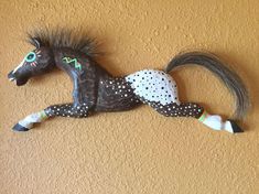 a decorative horse is mounted on the side of a wall in front of a stucco wall