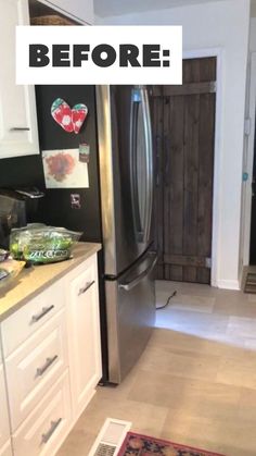 a stainless steel refrigerator in a kitchen with white cabinets and wood door, along with an area rug on the floor