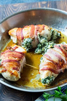 bacon wrapped chicken with spinach and cheese in a pan