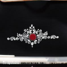 a black bag with white and red designs on the front is next to a pair of scissors