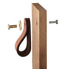 a wooden door handle with a nut and bolt on it's end, in front of a white background