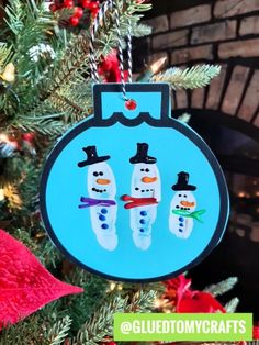 a christmas ornament with three snowmen hanging from it's side on a tree