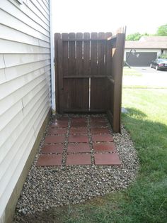 a wooden gate sitting next to a white house