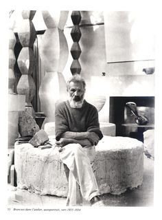 an old black and white photo of a man sitting on a bed