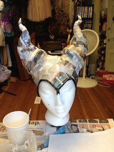 a mannequin's head is covered in newspapers and magazines as it sits on a table