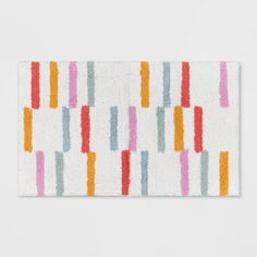 a white rug with multicolored stripes on it