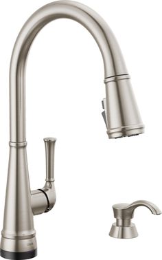 a kitchen faucet with two handles and one side sprayer on the sink