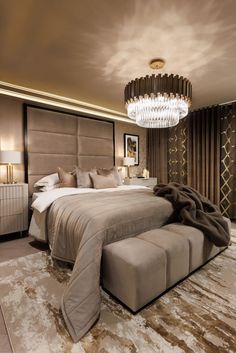 a large bed sitting in the middle of a bedroom next to a chandelier