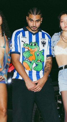 three models standing next to each other in front of a dark background, one wearing a t - shirt with a turtle on it