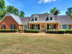 a red brick house surrounded by hedges and trees