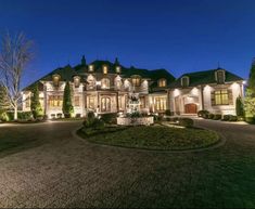 a large house with lots of lights on it's front lawn and driveway area