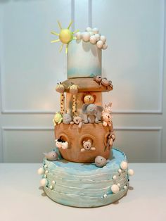 a three tiered cake decorated with animals and other things on it's side