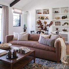 a living room filled with furniture and lots of bookshelves on top of it