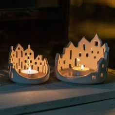 two white candles sitting on top of a table