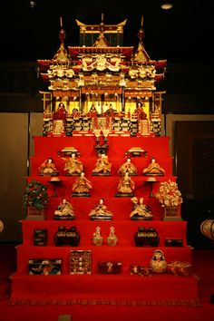 an elaborately decorated shrine in the middle of a room with red carpet and walls