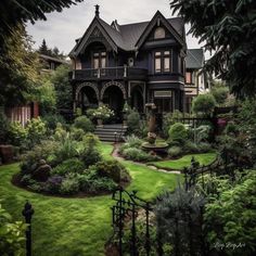 an old victorian style house surrounded by lush green grass