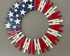 an american flag wreath made out of small wooden sticks and painted red, white and blue