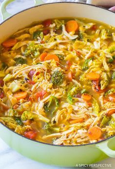 a pot filled with pasta and vegetables on top of a table