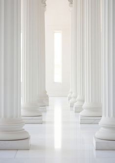 an empty room with white columns and marble floor