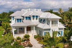 an aerial view of a large white house with blue shutters on the front and sides