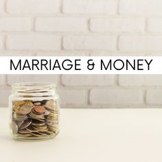 a jar filled with coins sitting on top of a table next to a white brick wall