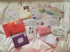 there are many different items on the bed together, including envelopes and other papers