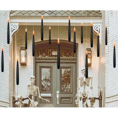 skeleton decorations hanging from the front door of a house