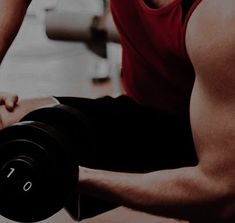 a man is doing exercises with dumbbells in the gym