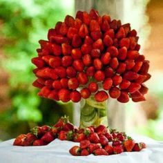 a bunch of strawberries sitting on top of a table next to a vase filled with them