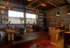 a room filled with lots of wooden furniture and bookshelves next to a window