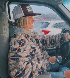 a woman sitting in the driver's seat of a car