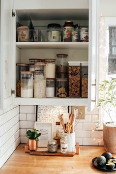 an organized kitchen with jars and containers on the shelves