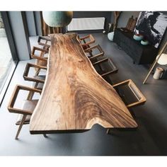 a long wooden table sitting in front of a large window on top of a floor