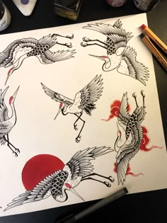 a drawing of some birds flying over a red sun and two black birds on white paper