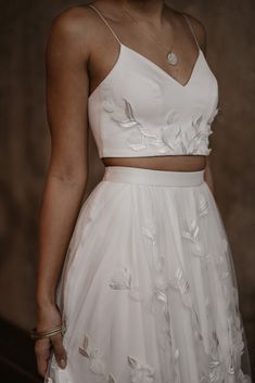 a woman wearing a white dress with flowers on it