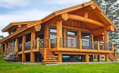 a large wooden house sitting on top of a lush green field