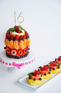 there is a cake with fruit on the top and another one in the middle, along with other desserts