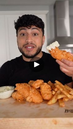 a man is holding up some food in front of him and pointing to the camera