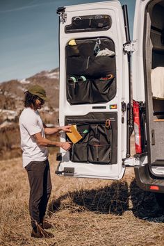 a man standing next to the back of a white van