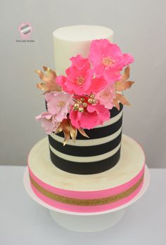 a black and white striped cake with pink flowers on top