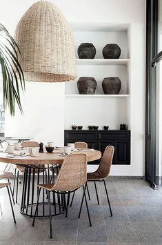 the dining room table is set with place settings and wicker baskets hanging from the ceiling