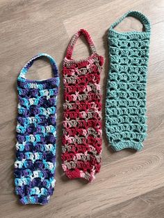 two crocheted bags sitting on top of a wooden floor next to each other